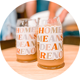 Two glasses that read 'Home Means Dean Reno' with orange juice in them